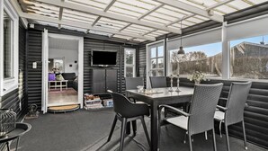 A sunroom with a TV, a dining table, and chairs. - Amazing home in Haderslev with WiFi (Haderslev)