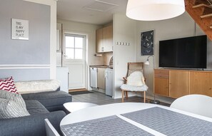 Relax in a cozy seating area with a sofa and chair, flat-screen TV, and dining table.