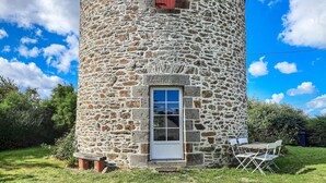 A stone tower with a white door and a small table with chairs outside. - 2 bedroom beach front home in Cherrueix (Cherrueix)