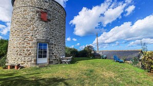 A stone tower with a door and window, surrounded by a grassy area with outdoor furniture. - 2 bedroom beach front home in Cherrueix (Cherrueix)