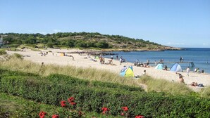 Een strand met tenten en mensen.