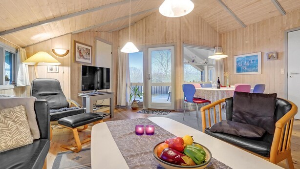 A cozy living room with a TV, comfortable seating, a dining area, and a view through a glass door. - Stunning home in Sydals with sauna (Sydals)