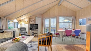 A cozy, well-lit living area with a sofa, a television, and a dining table with chairs. - Stunning home in Sydals with sauna (Sydals)