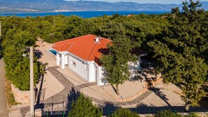 A white building with a red roof, surrounded by greenery and a clear view of the sea and mountains in the background. - Stunning home in Zestilac (Zestilac)