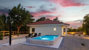 A modern house with a swimming pool, a covered patio, and a stone wall. - Stunning home in Zestilac (Zestilac)