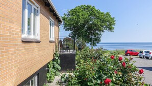 A brick house with a balcony overlooking a body of water. - 2 bedroom cozy home in Svaneke (Svaneke)