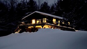 A snow-covered lodge with a wooden exterior and a balcony, surrounded by trees. - MINUTES TO STRATTON AND BROMLEY! (bondville)