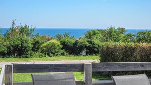 Una panchina di legno con vista sul mare e sul verde.