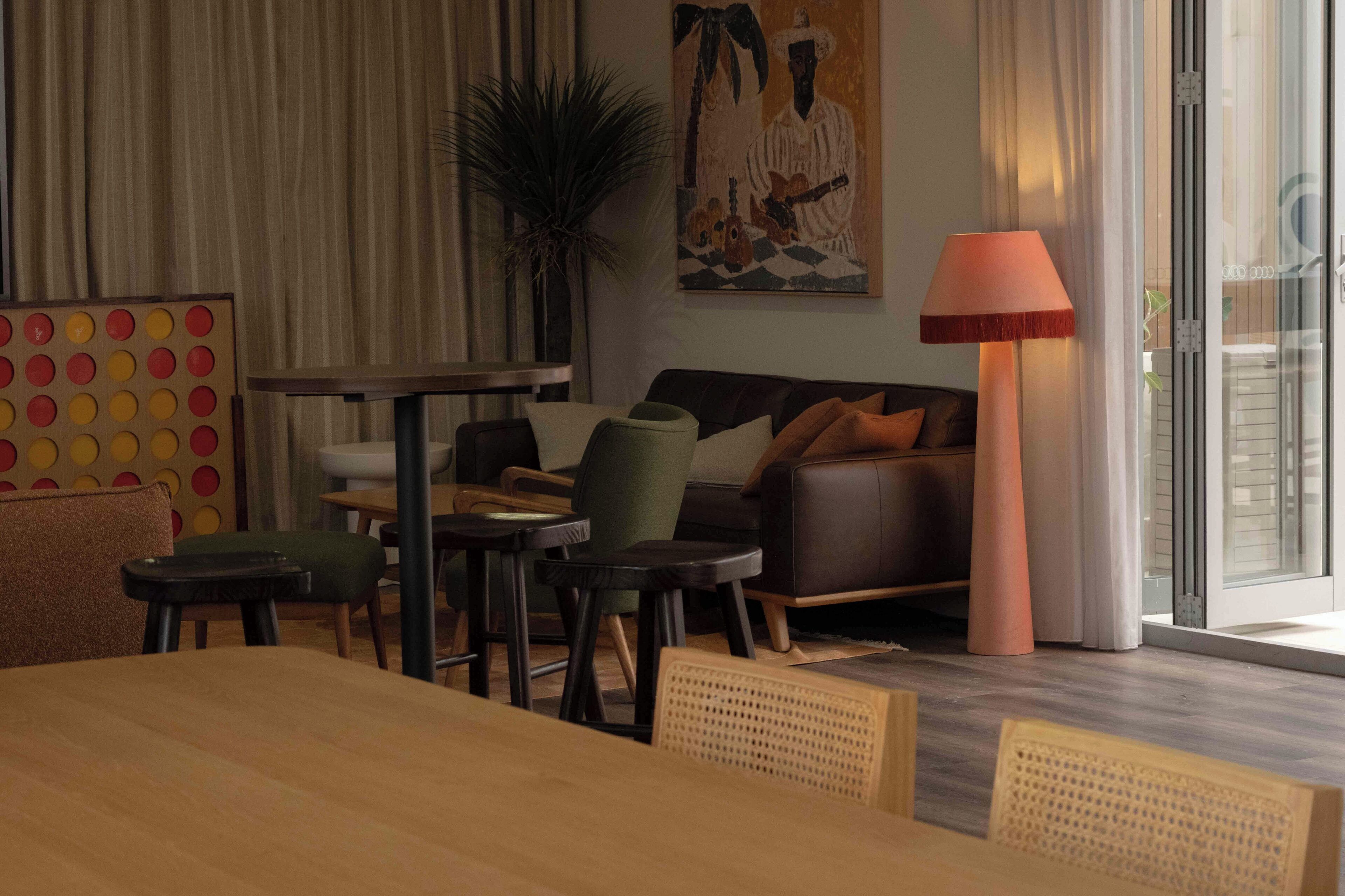 Una sala de estar moderna con un sofá, sillas, una mesa de centro y una lámpara.
