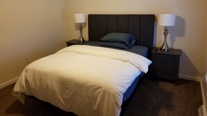 Een hotelkamer met een bed, twee nachtkastjes en twee lampen.