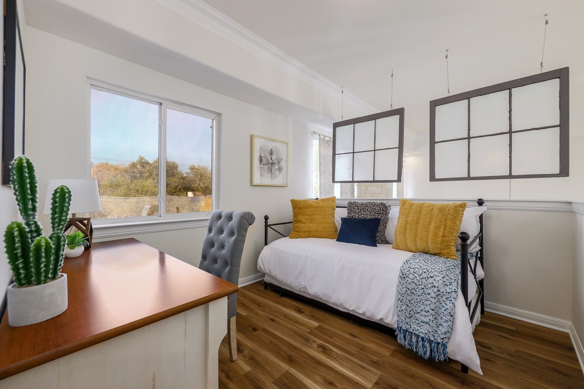 Une chambre à coucher avec un lit, un bureau, une chaise et une fenêtre.