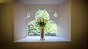 Une fenêtre avec un vase blanc contenant des fleurs blanches.