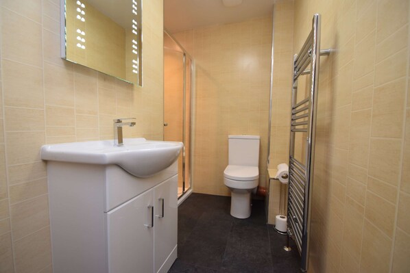 Une salle de bain avec un lavabo blanc, des toilettes et un porte-serviettes.