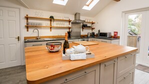 A modern kitchen with a wooden countertop, a built-in sink, and a skylight. - Bridgend Cottages (Llandrindod Wells)