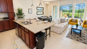 A modern kitchen with granite countertops, a sink, and a black trash bin. - 314 Festival (Davenport)