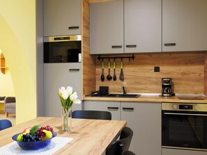 A modern kitchen with grey cabinets, a wooden countertop, a coffee maker, and a sink. - Apartment Jókai by Interhome (Balatonszarszo)