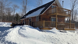 A wooden cabin with a balcony and a snow-covered deck. - Mountain View Cabin (Lovell)