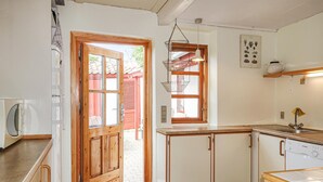 Una cocina con armarios de madera, un lavabo y un lavavajillas Bosch.
