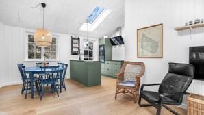 A modern kitchen with a dining area, a television, and a map on the wall. - Amazing home in Nexø with kitchen (Nexø)