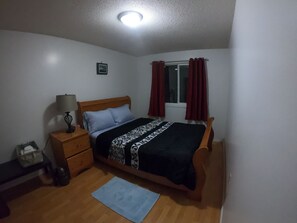 Relax in comfort with a single bed, nightstand, and dresser, set against a serene backdrop.