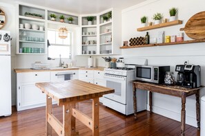 Enjoy cooking in this well-equipped kitchen with a central island, stove, microwave, and coffee maker.