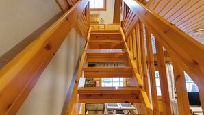 A wooden staircase with a view of the upper floor.