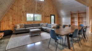 Un loft spacieux avec un intérieur en bois, une grande table à manger et un canapé d’angle.