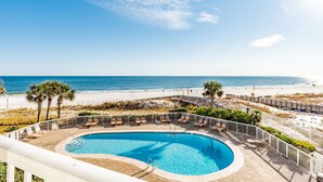 A pool area with a view of the beach and ocean.