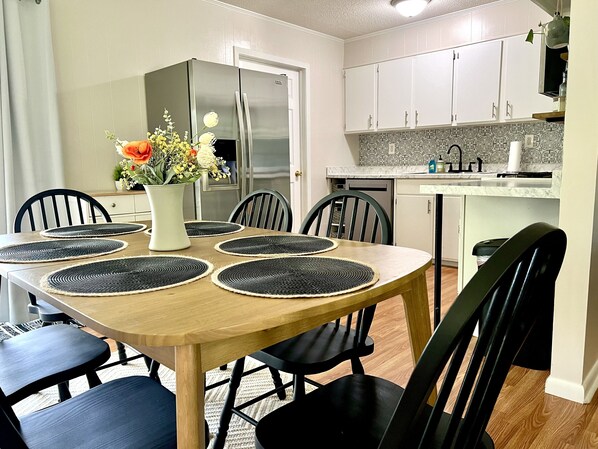 Enjoy meals in this kitchen with a dining table, sink, and refrigerator.