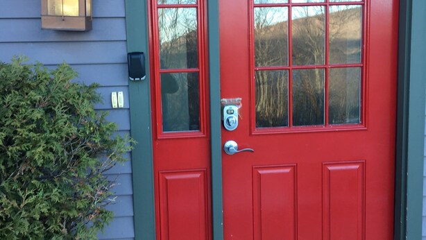 Una puerta roja con un buzón y una pequeña ventana encima.