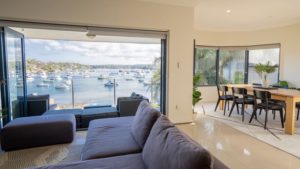 A modern living room with a large window overlooking a marina.