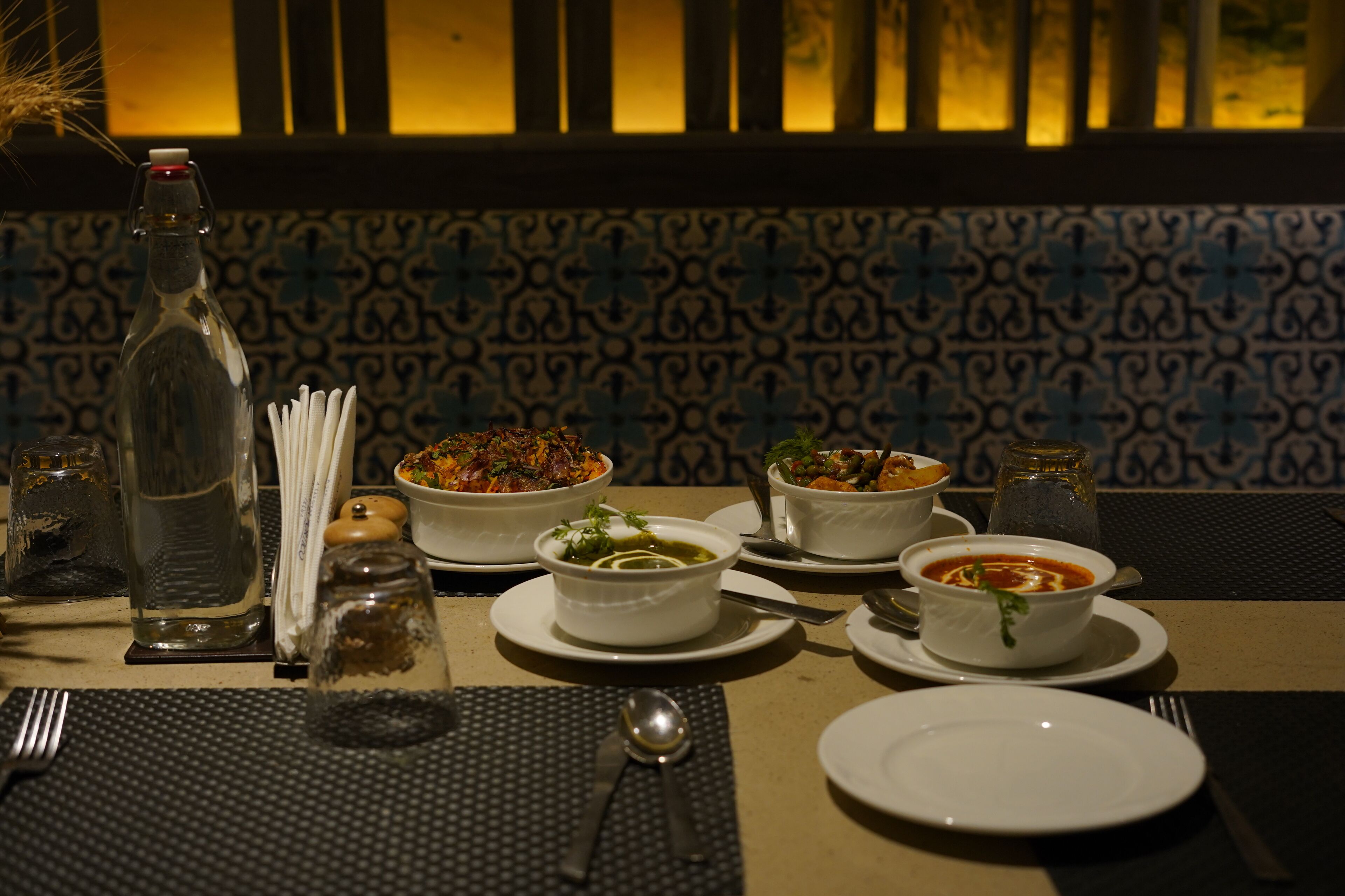 A table set with various dishes, a bottle, and condiments, suggesting a dining area.