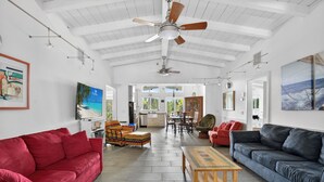A spacious living area with a high ceiling, ceiling fans, and a view to the outdoors. - Miles of Private Gulf Beach-Luxury 4 BR-Pets Okay-Kayaks & SUPs-Best Shark Teeth (Englewood)