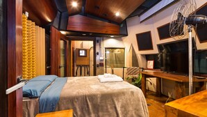 A bedroom with a bed, wooden furniture, a desk, and a fan. - VILA MADALENA: BEST LOCATION, ARTISTIC APARTMENT (São Paulo)