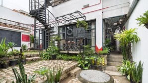 A courtyard with a spiral staircase, potted plants, and a round table. - VILA MADALENA: BEST LOCATION, ARTISTIC APARTMENT (São Paulo)