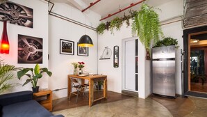 A modern kitchen with a dining area, a refrigerator, and a hanging plant. - VILA MADALENA: BEST LOCATION, ARTISTIC APARTMENT (São Paulo)