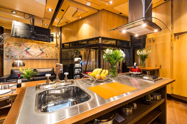 Een moderne keuken met een roestvrijstalen spoelbak, een fruitmand en een bloemenvaas.