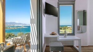 Ein Balkon mit Korbstühlen, einem kleinen Tisch und einem an der Wand befestigten Fernseher.