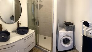 A compact bathroom with a sink, mirror, shower, and washing machine. - 77m2 T4 apartment (La Seyne-sur-Mer)