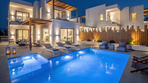 Una casa moderna a due piani con piscina, area salotto esterna e recinzione in legno.
