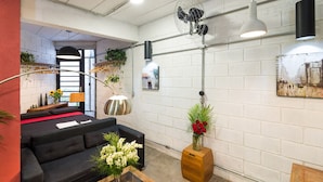 A modern living room with a black sofa, a wooden coffee table, and a white brick wall. - VILA MADALENA Perfect Location: Artistic Apartment (SP)