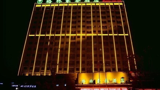 Un hôtel avec une enseigne bien visible sur le devant et une façade bien éclairée.