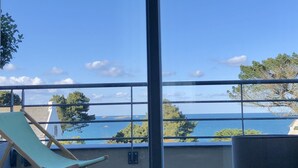 Ein Balkon mit Meerblick, einem Stuhl und einem Geländer.