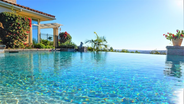 Une piscine aux eaux cristallines, offrant une vue sur un bâtiment et la végétation environnante.