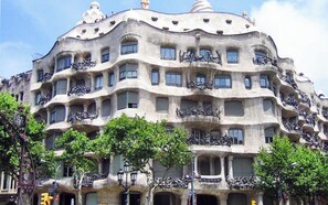 A building with a unique architectural style featuring balconies and windows. - Your solution for a perfect stay in Barcelona! (Barcelona)