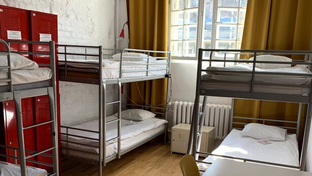 Un dormitorio con literas, un escritorio y una silla.