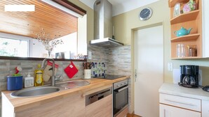 Eine moderne Küche mit einer Holz Arbeitsplatte, einer Edelstahl-Spüle und einem eingebauten Geschirrspüler.