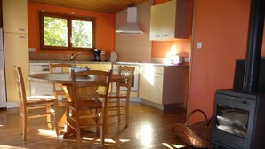 A cozy kitchen with wooden furniture, a stove, and a window providing natural light. - Your cabin, 1,500 meters from the Cascades-D waterfalls (Bonlieu)