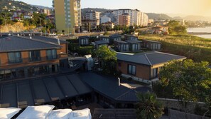 A residential area with modern houses, a river, and a distant mountain range.