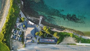 Vista aérea de una propiedad costera con una carretera, edificios y una playa.
